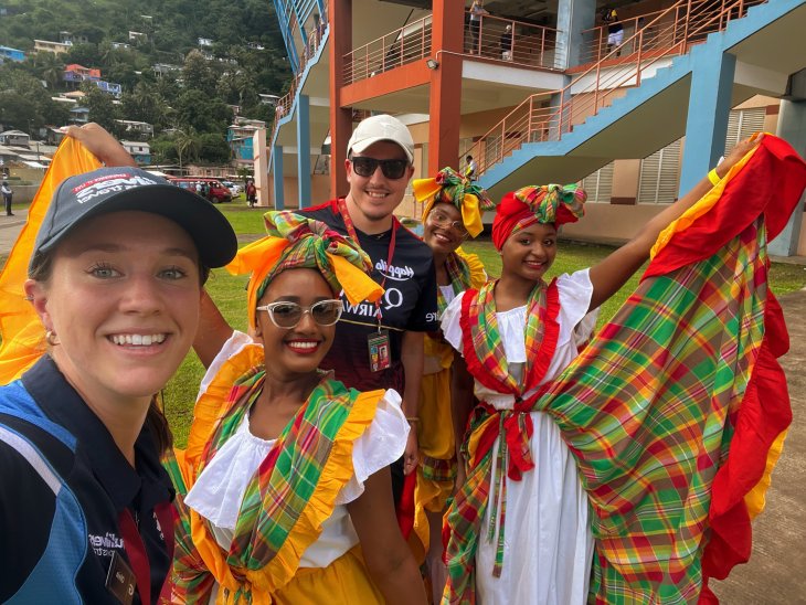 Staff members taking a photo with dancers in Barbados